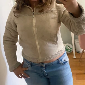 Beige teddyjacka från Trespass - Säljer en beige teddyjacka från Trespass i storlek small. Jackan har dragkedja framtill, mysigt teddyfoder och detaljer i samma material vid krage, ärmslut och nederkant. Perfekt för kyligare dagar och riktigt skön att ha på sig.