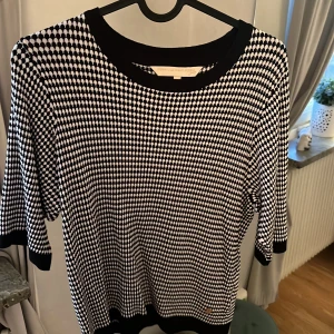 Svartvit mönstrad tröja från Pernilla Wahlgren - Säljer en svartvit tröja från Pernilla Wahlgren med rund halsringning och korta ärmar. Är i storlek Xs men passar S också är aldrig använd så den är som ny.
