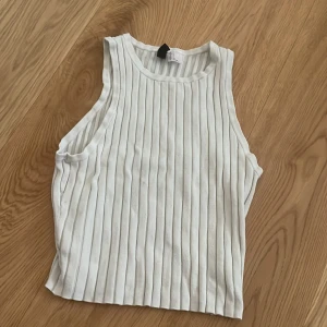 Vit ribbad linnetopp från Divided - Säljer en stilren vit ribbad linnetopp från Divided. Den är stretchih och ganska kort, bekväm!😁 