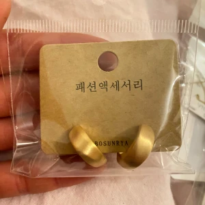 Guldiga örhängen från Bosunrya - Snygga och stilrena guldiga örhängen från Bosunrya. Perfekta för att ge en elegant touch till din outfit. Kommer i en praktisk förpackning.