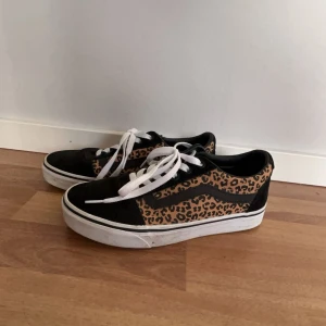 Vans skor  - Snygga Vans sneakers i svart med leopardmönstrade detaljer. Skorna har använts kanske 3 ggr och är i nyskick, endast lite smuts på sulan men de tvättar jag såklart bort innan jag skickar. Lådan till skorna har jag använt när jag slog in eb present så den är inte kvar, men jag skickar skorna i en annan skokartong. Priset är diskuterar bart!