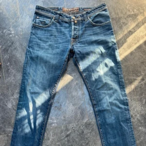 Blå jeans från Jacob Cohen 622 - Snygga blå jeans från Jacob Cohen 622 som inte fått mycket användning tyvärr. Jeansen är i perfekt skick och är precis som på bilden. Inga defekter eller liknande lukter eller hål. Modellen är 622 och storleken är 34 och passar mig som brukar ha 33 i midjan väldigt bra