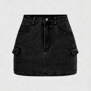 Svart jeanskjol med fickor - Snygg svart jeanskjol med praktiska fickor på sidorna och en knapp framtill. Perfekt för en cool och avslappnad stil.