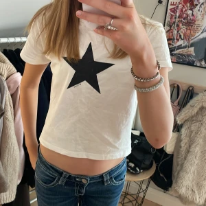 Vit t-shirt med svart stjärna - Säljer en vit t-shirt med en stor svart stjärna på framsidan. Tryck gärna på köp nu! 