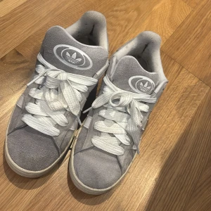 Gråa adidas campus - Hej! Säljer ett par gråa campus då dem inte kommer till användning. Perfekt för sommaren. Pris kan diskuteras lite. Jag rengör dem innan de postas. Postas inom 24 timmar efter de har blivit köpta. Kommer med ett extra par snören som är gråa