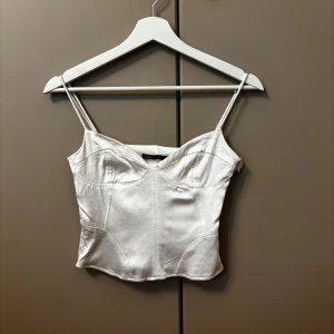 Vit korsett från Zara - Snygg vit korsett från Zara med tunna axelband och en elegant design. Perfekt för en stilren look.
