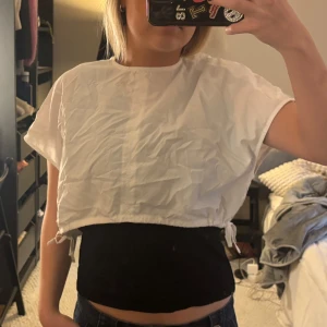 Vit kortärmad croppad topp - Säljer en vit kortärmad croppad topp med rund hals. 