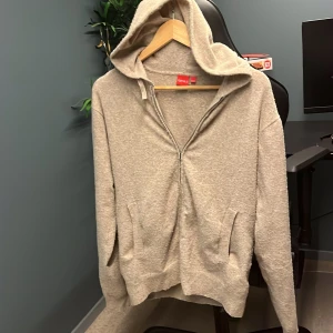 Beige hoodie från RYVLS - Säljer en beige hoodie från RYVLS med dragkedja och huva. Perfekt för en avslappnad stil. Den har långa ärmar och praktiska fickor framtill. Passar bra till både jeans och mjukisbyxor. 🧥