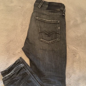 Grå Replay Anbass jeans - Snygga grå Replay Anbass jeans i slim fit. De har en cool slitningseffekt och klassiska femficksdesign. Perfekta för en stilren look.