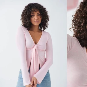Rosa långärmad topp från Gina Tricot - Säljer en söt rosa långärmad topp från Gina Tricot. Toppen har en knytning framtill och en v-ringad design!