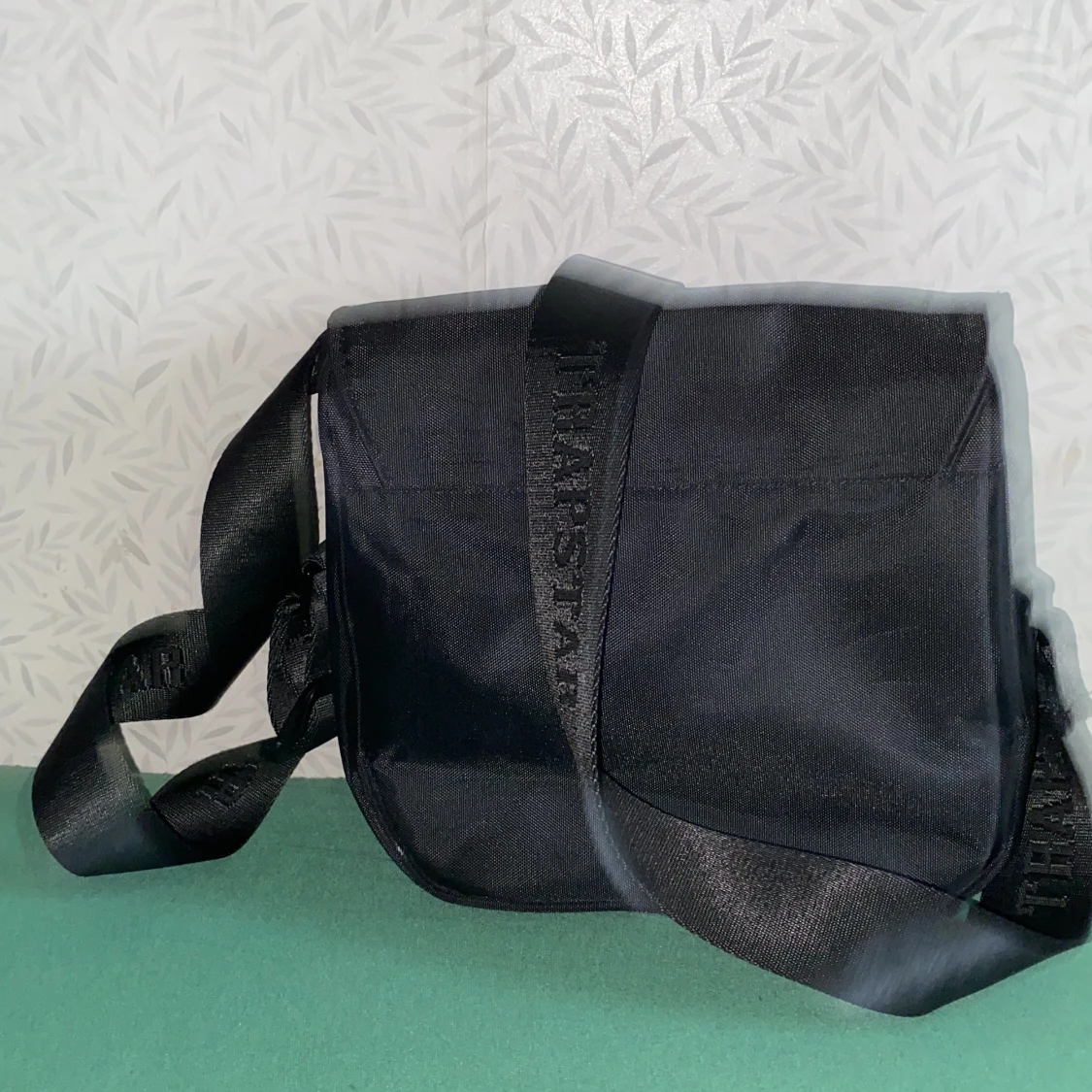 Svart axelväska med dekorativt emblem - 1