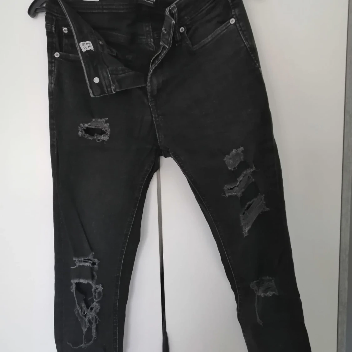 Svarta jeans med slitningar