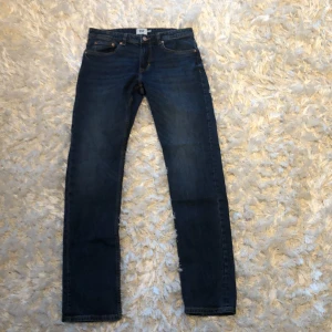 Mörkblå jeans från lager 157 - Snygga mörkblå jeans från lager 157 med klassisk femficksdesign och knappgylf. Perfekta för en stilren look. Märkeslappen syns tydligt på baksidan.