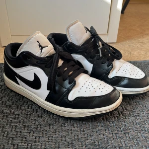 Nike Air Jordans Storlek 37 1/2 - Snygga Nike Air Jordans i klassisk svart och vit färgkombination. Skorna har en ikonisk design med snörning och perforerade detaljer på tån för extra ventilation. Perfekta för både stil och komfort. Storlek 37 1/2