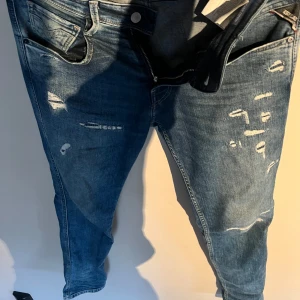 Blå jeans med slitningar - Snygga blå jeans med slitningar från Replay. 