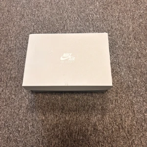 Vita Nike Air Force sneakers - Säljer ett par klassiska vita Nike Air Force sneakers. De har en stilren design med snörning och är perfekta för en casual look. Skorna är i syntetmaterial och kommer i originalkartong.