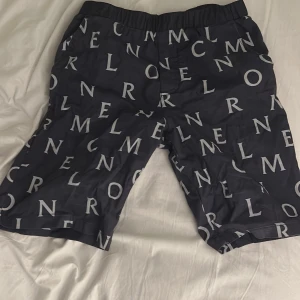 Svarta shorts med bokstavsmönster från Moncler - Snygga svarta shorts från moncler. Skick 10/10 används en-två gånger. Ny pris 2500. 