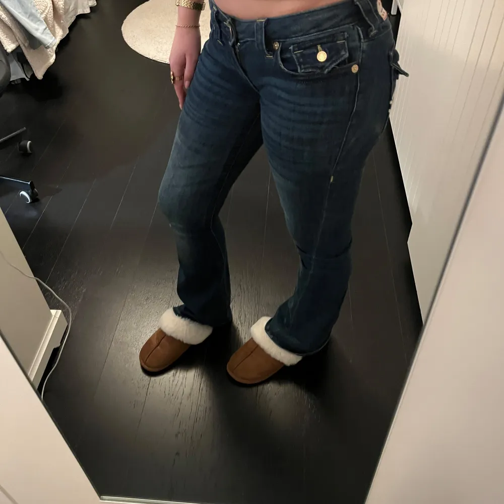 Snygga lågmidjade mörkblå jeans från true religion i modellen joey💓de har superfina och coola fickor men ena fickan saknar däremot en knapp, därav priset (de köptes för 1700kr), men det är inget som skapar problem för mig. De är använda hyfsat mycket och töjt sig så skulle säga att de gått upp en storlek (från 26)💓 säljer pga de används inte lika mycket som förut men de är fortfarande i bra skick⭐️. Farkut & Housut.