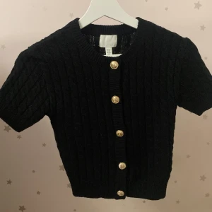 Svart ribbad kofta med korta ärmar - Säljer en stilren svart kofta med korta ärmar och ribbad design. Den är jättefin och är i storlek XSS. Helt ny, bara använt en gång.❤️❤️