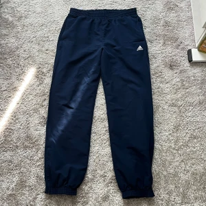 Träningsbyxor Adidas - Mörkblå träningsbyxor från Adidas. Har sytts efter hål (se bild 2)