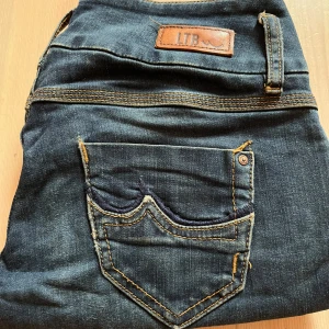 Mörkblå jeans från LTB - Snygga mörkblå jeans från LTB med klassiska kontrastsömmar och coola detaljer på bakfickan. Jeansen har en klassisk femficksdesign och är tillverkade i mjukt denimtyg som sitter skönt hela dagen.