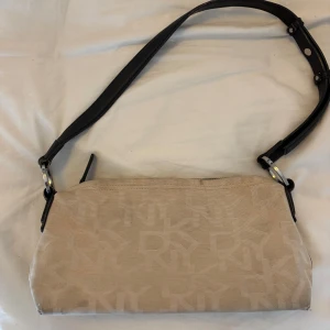 Beige axelväska vintage från DKNY - Bra skick i helhet men det är lite smutsig så eventuellt rengöra den lite om man vill. Har en liten fläck på ena sidan (sista bild)