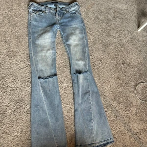 True Religion ljusblå bootcut jeans - Ljusblå jeans från True Religion med bootcut. Har sprättat upp dem där ner så att dem passar mig som är 175 cm