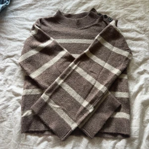  brun stickad tröja  - Mysig brun stickad tröja från Vero Moda med knappar på ena axeln! 