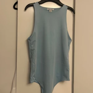 Ljusblå body från new yorker - En stilren ljusblå body med rund halsringning. Enkel och snygg design utan mönster eller detaljer, perfekt.