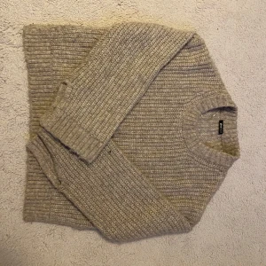 Beige stickad tröja från Gina Tricot - Mysig beige stickad tröja från Gina Tricot i storlek S. Tröjan har grovstickad struktur, rund halsringning och långa ärmar. Perfekt för lager-på-lager och chill höst- och vinterstil.🍁🍂🥮