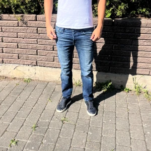 Blå straight jeans  - Snygga blå jeans från Jack and Jones. Jeansen har en mörk tvätt med lätt slitning och kontrastsömmar. Killen på bilden är 182 cm. As bra skick och redo att användas 