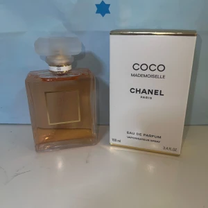 Chanel Coco Mademoiselle EdP 100ml - Chanel Coco Mademoiselle Eau de Parfum i elegant, fyrkantig glasflaska med guldig etikett och frostad kork. Parfymen är bärnstensfärgad och kommer i original vit kartong med guldiga detaljer. Klassisk och lyxig doft från Paris, 100 ml spray.
