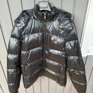 Polo ralph lauren dunjacka - En väldigt populär polo ralph lauren dunjacka i färgen svart. Den är i storlek M, men passar även L. Det finns endast ett fåtal tecken på användning. Orderbekräftelse finns för att intyga äktheten. Skriv gärna vid funderingar!