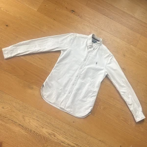 Ralph Lauren Skjorta (pris diskuterbart) - !! NY SKICK !! Klassisk vit skjorta från Ralph Lauren med button-down krage i SLIMFIT och broderad logga på bröstet. Skjortan har lång ärm, tillverkad i bomull. Perfekt till jeans för en clean och stilren look. storlek 20 Sitter som en S-M