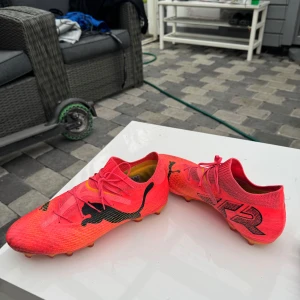 Puma fotbollsskor - Säljer ett par grymma fotbollsskor från Puma köpta för 1600kr i neonrosa med svarta detaljer och logga. Skorna har snörning, stickad strumpkrage och mönstrad sula för bästa grepp på planen. Lätta och flexibla i syntetmaterial, perfekta för dig som vill sticka ut på matchen.
