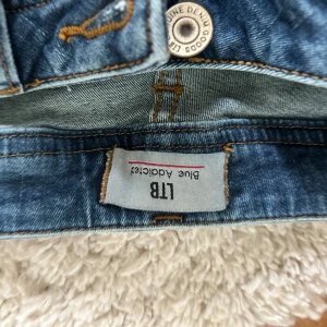 Blå jeans från LTB Blue Addiction - Säljer ett par klassiska blå jeans från LTB Blue Addiction. Jeansen har raka ben, snygga slitningar och kontrastsömmar. De har fem fickor och läderpatch bak. Har tyvärr lite vita färg fläckar❤️ i storlek s-m