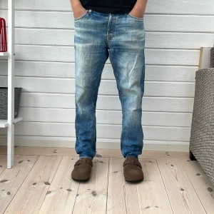 Blå jeans från Jack & Jones Comfort/Mike - Snygga blå jeans från Jack & Jones, modell Comfort/Mike. Jeansen har en klassisk femficksdesign, normal passform och coolt tvättad look med ljusa partier framtill och baktill. Tillverkade i bomull med en rak siluett och midwaist.