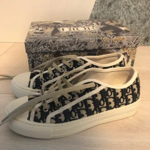 Dior sneakers  - Snygga Dior sneakers i beige och mörkblått med klassiskt Dior-monogram över hela skon. Står storlek 42 men innersulan är 26cm så skulle säga 40❣️