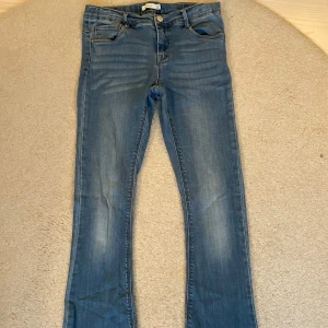 Blå bootcut jeans med normal midja - Snygga blå jeans med bootcut och normal midja. Jeansen har klassisk femficksdesign, dragkedja och knapp framtill. Materialet är mjukt denim. Perfekta till sneakers eller boots. Säljer dem eftersom det är för små för mig tyvärr. (Är 168cm men har långa ben)