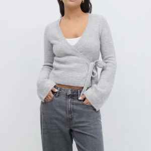 Grå omlottkofta med knyt - Jag säljer en superfin grå kofta med rosett från ginatricot då den inte kommer till användning! Bara använt ett fåtal gånger och därför väldigt bra skick.                                                                     Pris kan diskuteras!!🩷