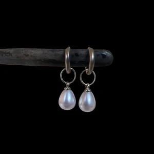 Silverörhängen med vita pärlor - Stilrena örhängen i silverfärg med droppformade vita pärlor som hänger från små ringar. Perfekta för dig som gillar en klassisk men ändå trendig look. Pärlorna ger en elegant touch och passar till många olika stilar. Rostfria! 