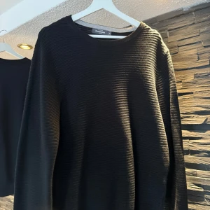 Svart ribbad tröja från Dressmann - M - Svart långärmad tröja från Dressmann med ribbad struktur. Storlek M