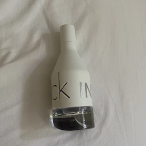 CK IN2U parfym - Säljer en stilren CK IN2U parfym från Calvin Klein. Flaskan är vit med genomskinlig botten och har en modern, minimalistisk design med silvriga bokstäver. Perfekt för dig som gillar fräscha och ungdomliga dofter. Den är helt ny! Endast testad!! Skriv vid minsta fundering och skicka gärna in prisförslag!