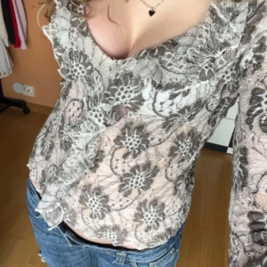 Blommig spetsblus med volang - Supersöt vintage blus, knappt använd. storlek L/14 men känns mer som en S/36 :) 📏 Mått (mätt platt): Axelbredd: 23cm Längd: 71cm Jag bär S/36 och är 170cm Hör av dig vid fler frågor!💕