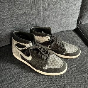 Nike Air Jordan 1 Flyknit svart/vit - Nike air flyknit grå. Storlek är 45,5 tyvärr finns ej box då den kommit bort. Gammal sko men knappt använd. Cond 7/10. Finns att hämta i Bromma