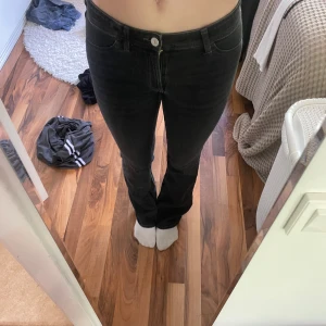 Svarta bootcut jeans - Säljer ett par svarta jeans med bootcut-modell och klassisk femficksdesign. Jeansen har hög midja och är tillverkade i ett stretchigt denimtyg som sitter snyggt över höfterna och låren. Perfekta för dig som gillar en tidlös och clean look. Endast testade!