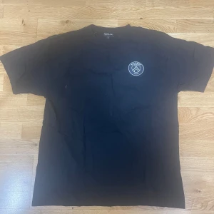 Svart t-shirt New Black x Halebop - Svart t-shirt från New Black med Halebop Sverige-tryck på bröstet. Klassisk rund halsringning och korta ärmar. T-shirten är i bomull och har en clean, stilren look som passar perfekt till jeans eller shorts.