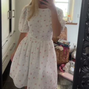 Vit blommig kortklänning med öppen rygg - Slutsåld superfin sommarklänning med öppen rygg. Den är helt oanvänd med lappen kvar💞Min egna bild första och sista bilden