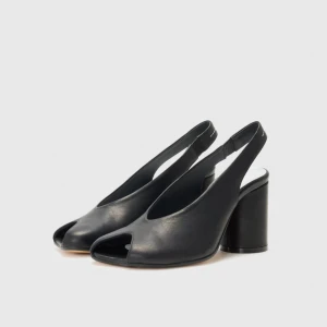 Svarta pumps  Maison Magiela - Stilrena svarta pumps i skinn med öppen tå och bred hög klack. Snygg slingback-modell med rundad form och minimalistisk design. Perfekta för dig som vill ha en klassisk men modern look.