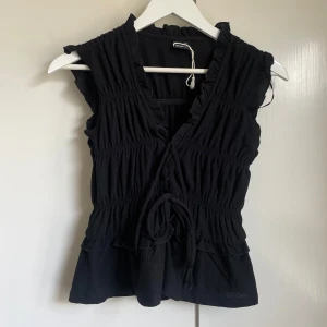 Blus med volanger - Blus med volanger från Gina tricot, oanvänd. Storlek XS